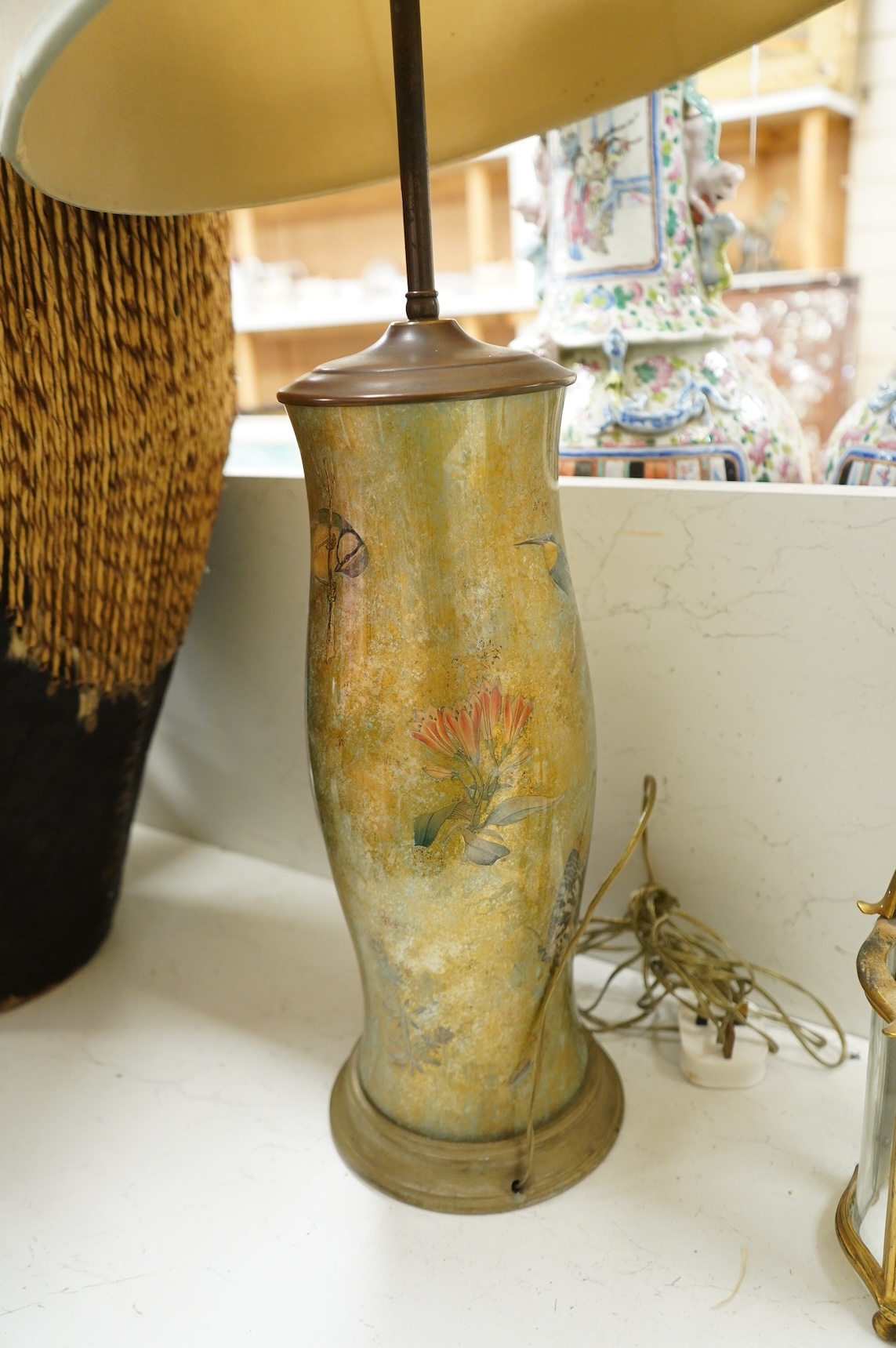 A pair of table lamps and shades, 92cm high, the lamps decorated in gold and green tones painted with birds and flowers, together with a small glass and brass hall lantern (3).